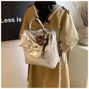 Detailansicht eines stylischen silbernen Metallic-Rucksacks mit Herzanhänger und Drehverschluss