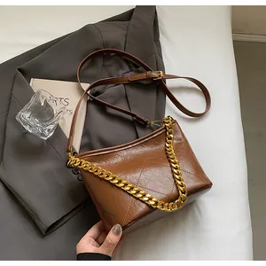 Detailansicht der braunen Stepptasche mit goldener Kette und Kunstleder-Textur