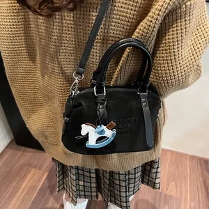 Borsa bowling nera in finta pelle scamosciata con doppi manici e ciondolo a cavallo