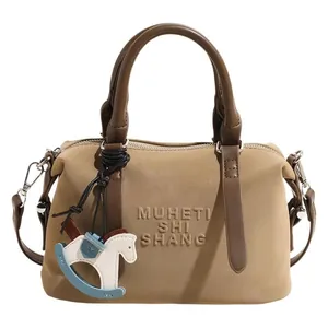 Borsa bowling alla moda in morbida pelle beige e marrone con ciondolo a cavallo