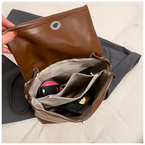 Detailansicht der Innenseite einer braunen Ledertasche mit vielen Fächern und Innenfutter
