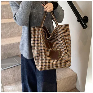 Houndstooth draagtas met bruine appel-patches getoond in een lifestyle-omgeving
