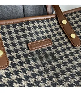 Detail of houndstooth tote bag featuring a leather patch with Fashion & Bag logo