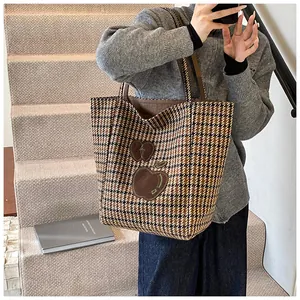 Macro-opname van de houndstooth shopper met bruin appelborduurwerk en geweven textuur