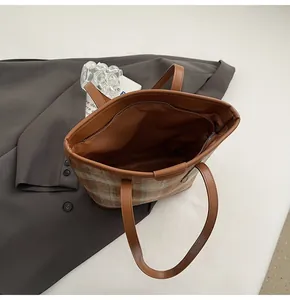 Vue détaillée d'un sac cabas en tweed à carreaux avec intérieur spacieux et anses en PU