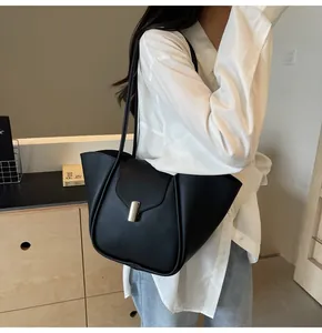 Détail d'un sac cabas en cuir noir avec fermoir doré élégant et côtés structurés