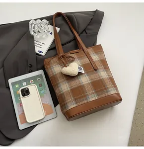 Vue détaillée du sac cabas à carreaux marron avec poignée en cuir et charm
