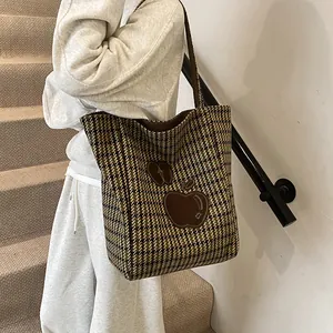Klassieke shopper met pied-de-poule patroon en bruine appelborduring gedragen door model