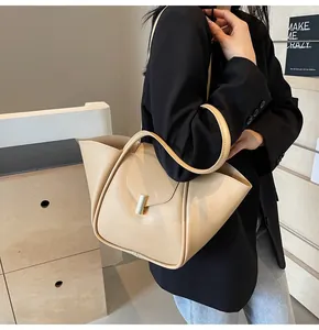 Gros plan du sac à main beige au design ailé avec fermoir magnétique doré et cuir lisse