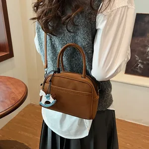Brown vintage Boston shoulder bag with a cute rocking horse charm and matte finish
