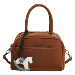 Fashionable brown matte Boston handbag for women with cute Trojan horse pendant charm