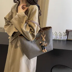 Houndstooth tote bag with brown leather handles and a plush rabbit pendant for women