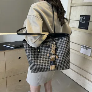 Classic houndstooth tote bag with black leather straps and a cute bunny doll charm