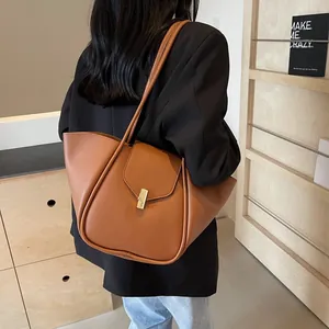 Sac fourre-tout marron caramel avec boucle dorée présenté dans un style de vie quotidien