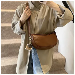 Detail view of brown PU leather half-moon crossbody bag with a cute pinecone pendant