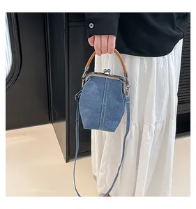 Detailed view of denim shell bag featuring retro doctor-style closure and contrast stitching