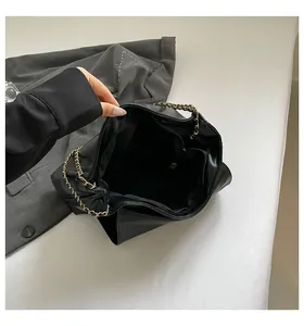 Top view of open black leather handbag showing spacious interior with zipper pocket