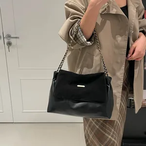 Chic black patchwork shoulder bag with suede flap and elegant woven chain strap