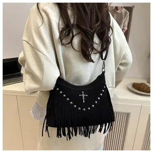 Close-up of black suede crossbody bag with gothic silver cross and long fringe details