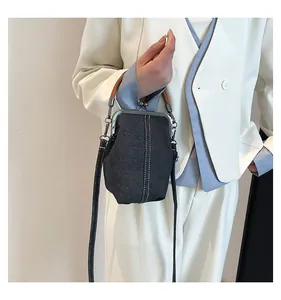 Detailed close-up of a mini denim doctor bag featuring retro metal clasp and contrast stitching