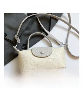 Detail view of contrast color crossbody bag with snakeskin texture and grey top handle