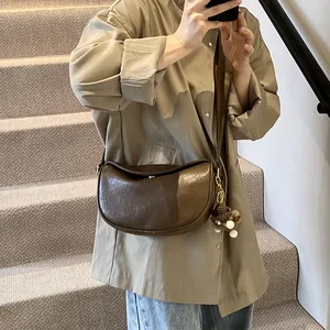 Vintage dark brown crescent shoulder bag in oil wax faux leather worn by a model