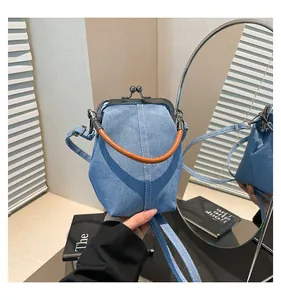 Detail of vintage denim shell bag featuring retro metal clasp and white topstitching