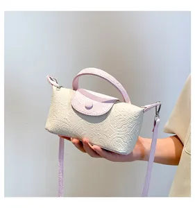 Detailed macro view of the cream and pink textured handbag surface with embossing