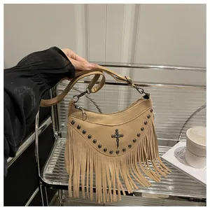 Close-up of khaki suede crossbody bag featuring retro fringe, metal rivets and cross badge