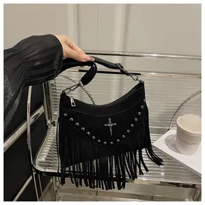 Detail of black crescent shoulder bag with silver studs, tassels, and cross charm