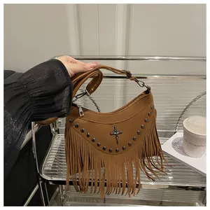 Detail of brown fringe crossbody bag with silver cross stud and rivet accents