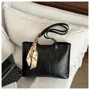 Detailansicht der schwarzen Tote Bag mit Seidenschal und hochwertiger Lederstruktur
