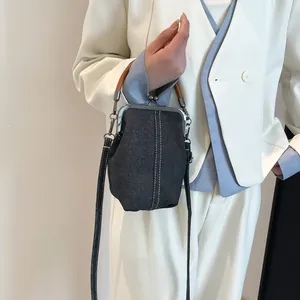Retro denim doctor bag with wooden top handle and metal clasp in a stylish crossbody look