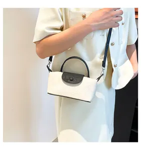 Detail of a contrast mini tote bag with embossed white leather and black flap