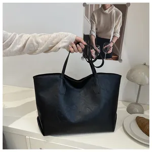 Close-up of black leather tote bag showing high-quality textured finish and sturdy handles