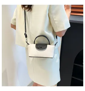 Rear view of a model wearing the white floral relief mini crossbody bag with black handles