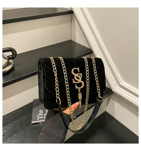 Détail du velours noir matelassé avec logo doré et pendentif à pampille raffiné