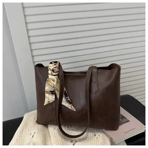 Nahaufnahme braune PU-Leder-Tote Bag mit elegantem Blumenschal-Detail am Tragegriff