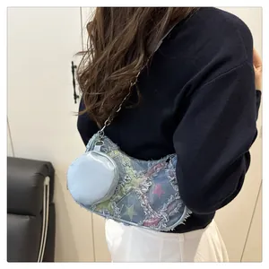 Dettaglio della borsa sottobraccio patchwork in denim con catena e stelle colorate