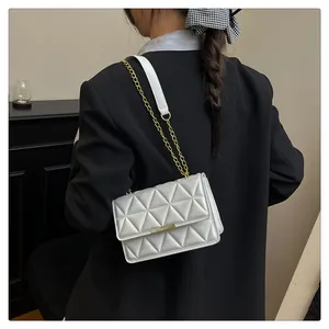 Close-up of quilted geometric pattern and gold chain strap on stylish shoulder bag