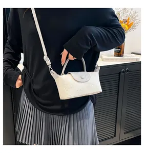 Detail of floral embossed cream mini bag with grey handles and adjustable strap
