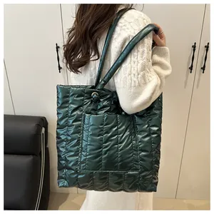 Detailed view of dark green quilted tote bag with vertical stitching and glossy finish