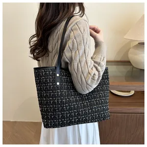 Détail du sac cabas en tweed avec bandoulière en cuir noir et rivets métalliques dorés