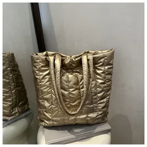 Detail of golden quilted tote bag showing high-gloss metallic finish and soft texture
