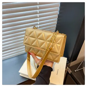Detail of champagne gold crossbody bag with geometric triangle pattern and gold chain