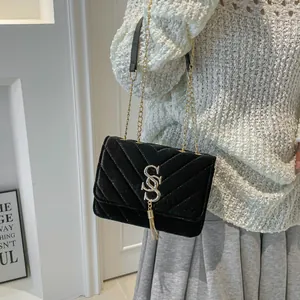 Sac bandoulière élégant en velours noir avec matelassage en V et pompon doré