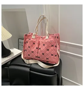 Detailed view of pink corduroy crossbody bag with bow patterns and adjustable strap