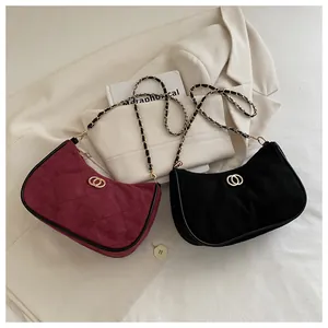 Quilted chain shoulder bags in wine red and black displayed on a soft beige blazer