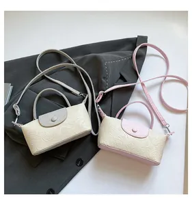 Detail view of two-tone crossbody bags with embossed patterns and adjustable straps
