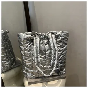 Detail of silver quilted puffer tote bag featuring metallic finish and vertical stitching